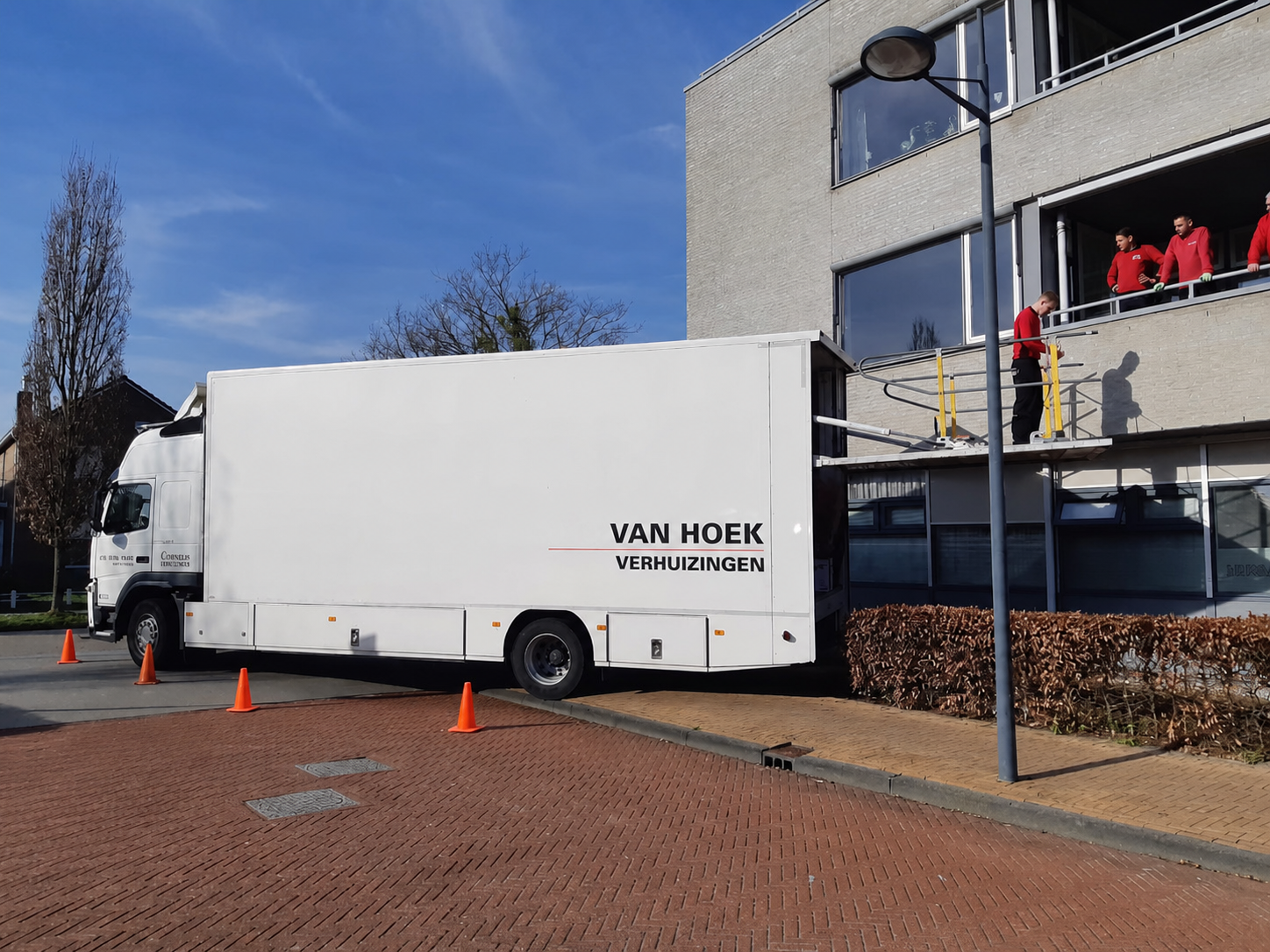 vrachtwagen Witte vrachtwagen met logo Van Hoek Verhuizingen